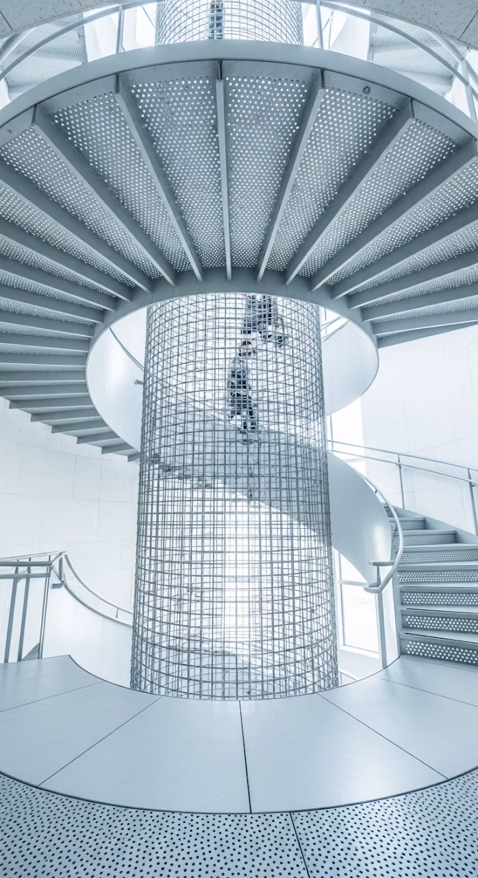 Abstract View of Modern Metal Spiral Staircase with Central Wire Mesh Cage - Free Mobile AMOLED Wallpaper Background