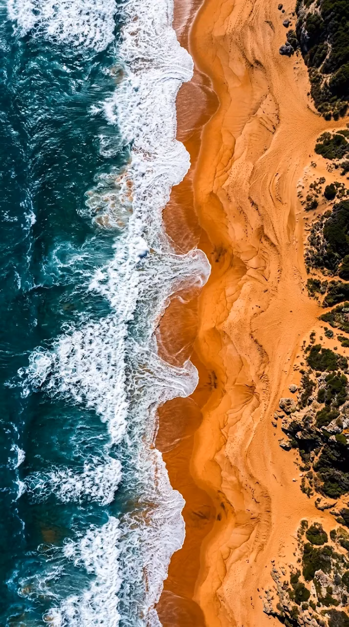 Download Aerial Top-Down View of Teal Ocean Waves Meeting Vibrant Orange Sands Wallpaper in Mobile HD Aerial Top-Down View of Teal Ocean Waves Meeting Vibrant Orange Sands - Free Mobile AMOLED Wallpaper Background