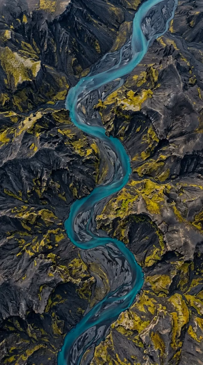 Download Aerial Top-Down View of Teal River Winding Through Mossy Volcanic Mountains Wallpaper in Mobile HD Aerial Top-Down View of Teal River Winding Through Mossy Volcanic Mountains - Free Mobile AMOLED Wallpaper Background