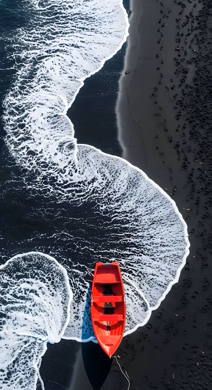 Aerial View of Red Boat on Black Volcanic Sand Beach - Free Mobile AMOLED Wallpaper Background