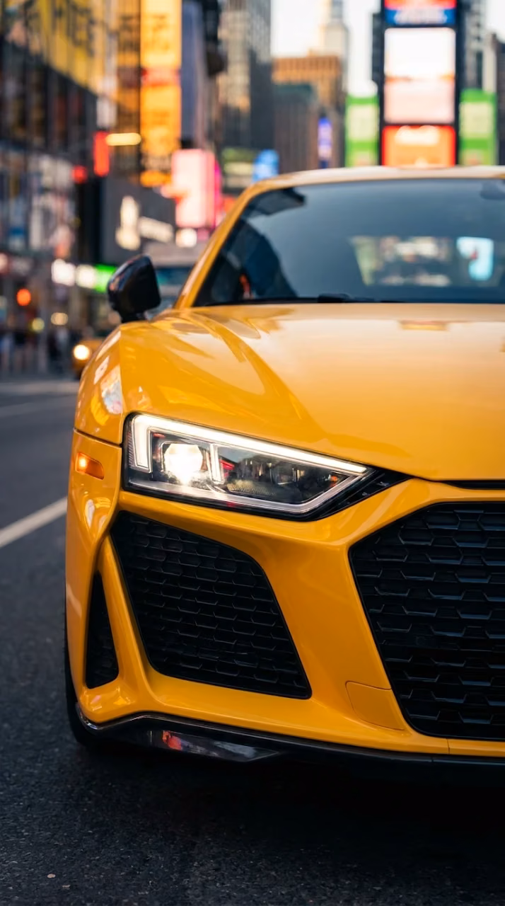 Close-Up of Yellow Sports Car Headlight on City Street - Free Mobile AMOLED Wallpaper Background