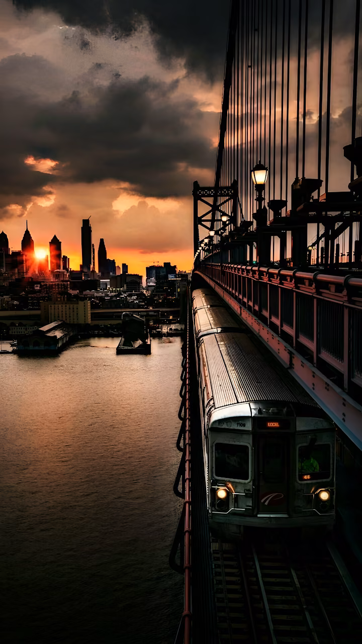 Commuter Train Crossing Bridge at Dramatic Sunset Skyline - Free Mobile AMOLED Wallpaper Background