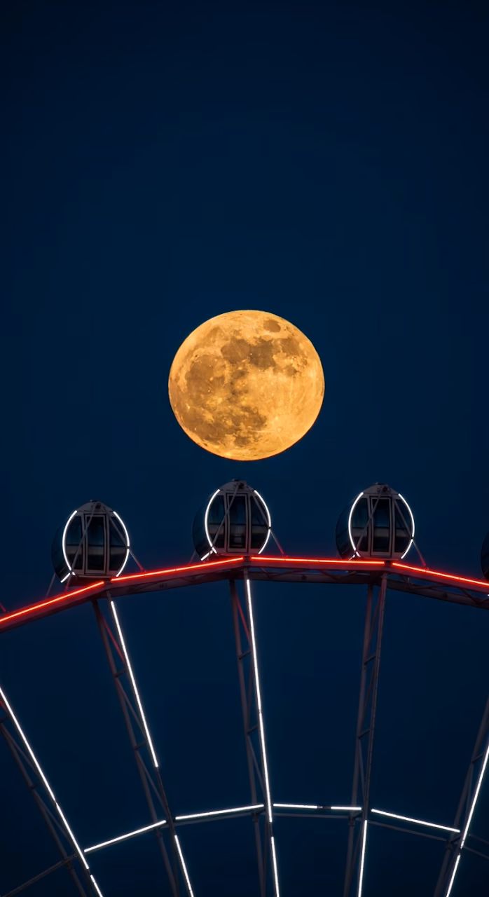 Download Dramatic Telephoto Shot of Giant Full Supermoon Rising Over a Modern, Red-Lit Observation Wheel Wallpaper in Mobile HD Dramatic Telephoto Shot of Giant Full Supermoon Rising Over a Modern, Red-Lit Observation Wheel - Free Mobile AMOLED Wallpaper Background