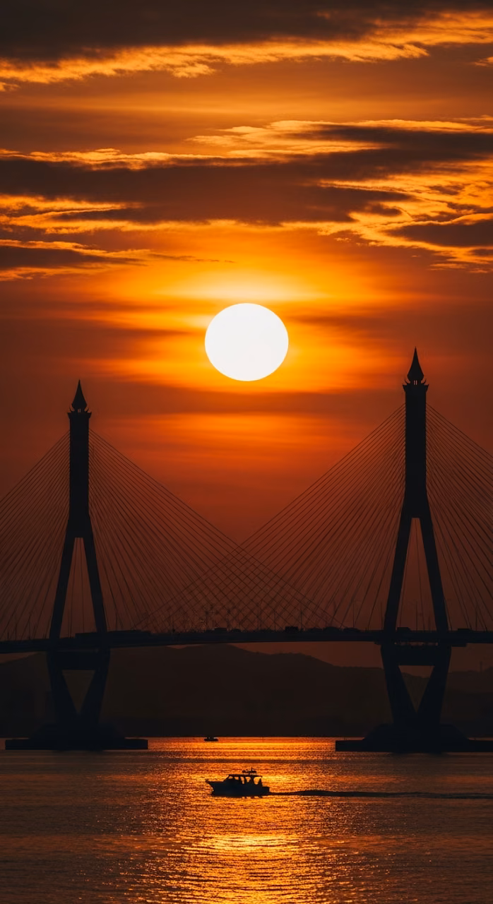 Epic Silhouette of a Bridge and Boat Against a Fiery Sun and Intense Red-Orange Sunset Sky Over Water - Free Mobile AMOLED Wallpaper Background