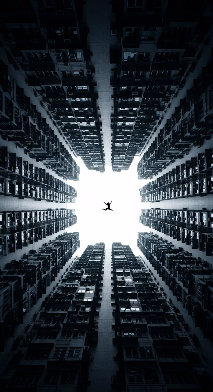 Extreme Low-Angle View of Towering Urban Canyon with Silhouetted Figure Falling - Free Mobile AMOLED Wallpaper Background