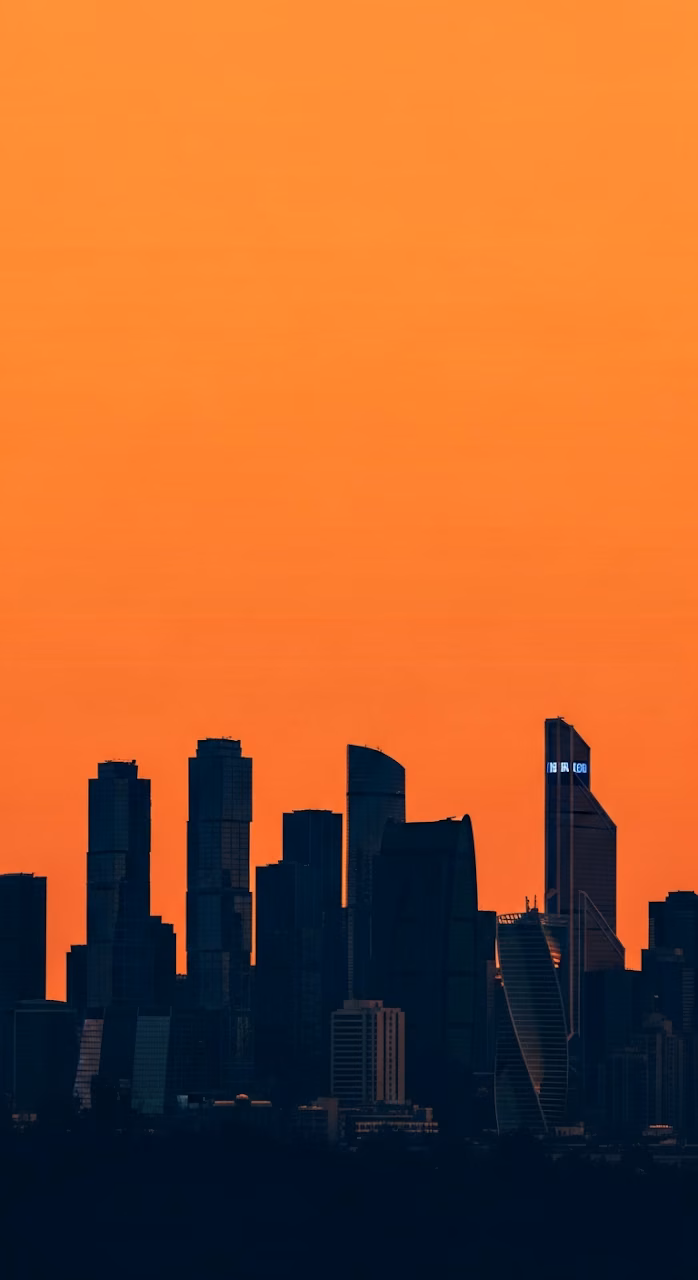 Download High-Contrast Graphic Silhouette of a Modern City Skyline Against a Vast Monochromatic Orange Sky Wallpaper in Mobile HD High-Contrast Graphic Silhouette of a Modern City Skyline Against a Vast Monochromatic Orange Sky - Free Mobile AMOLED Wallpaper Background