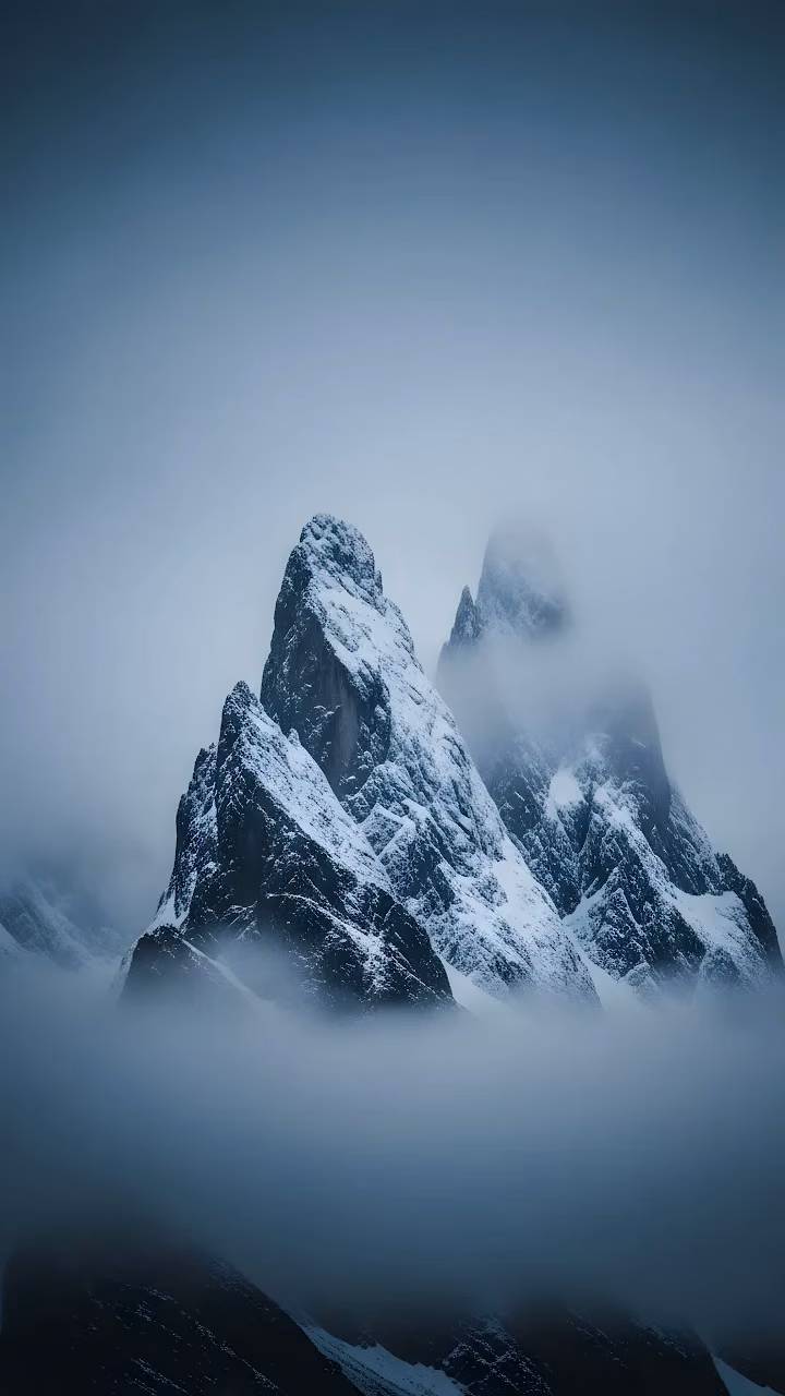 Jagged Snow-Covered Alpine Peaks in Dense Fog - Free Mobile AMOLED Wallpaper Background
