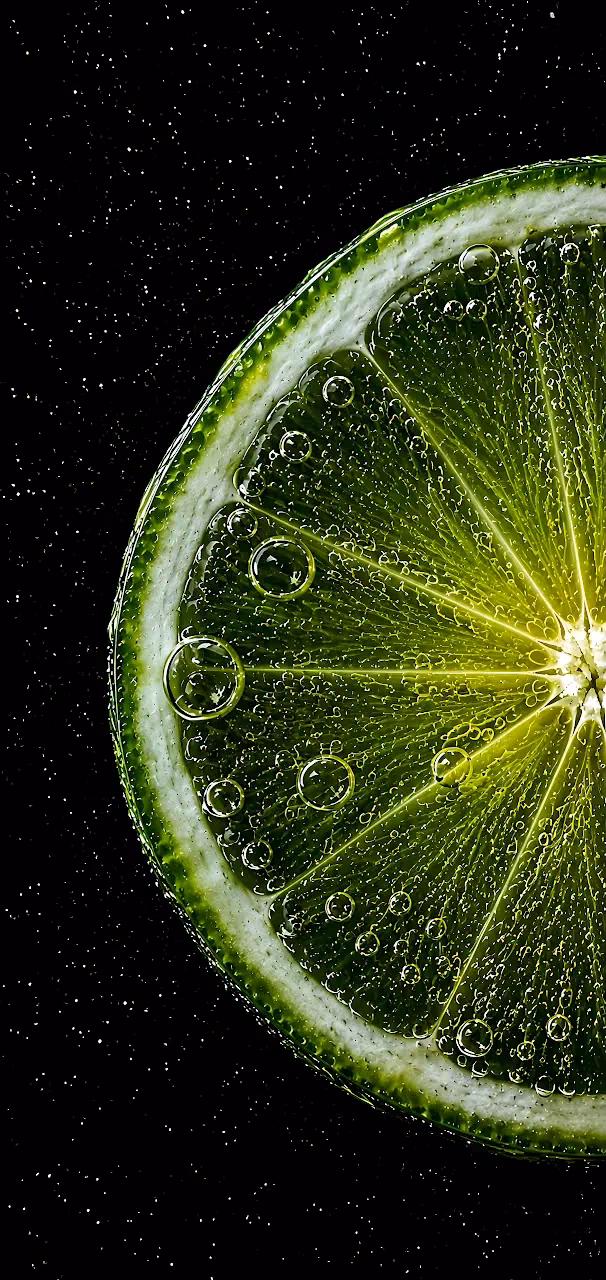 Download Lime Slice Water Bubbles 4K Wallpaper in Mobile HD Close-up of a backlit green lime slice surrounded by sparkling bubbles on black.