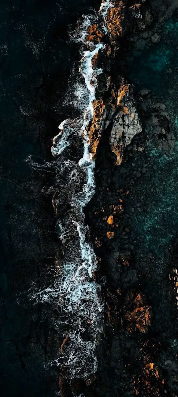 Moody Aerial View of Crashing Waves on Dark Volcanic Coastline - Free 4K Desktop Wallpaper Background