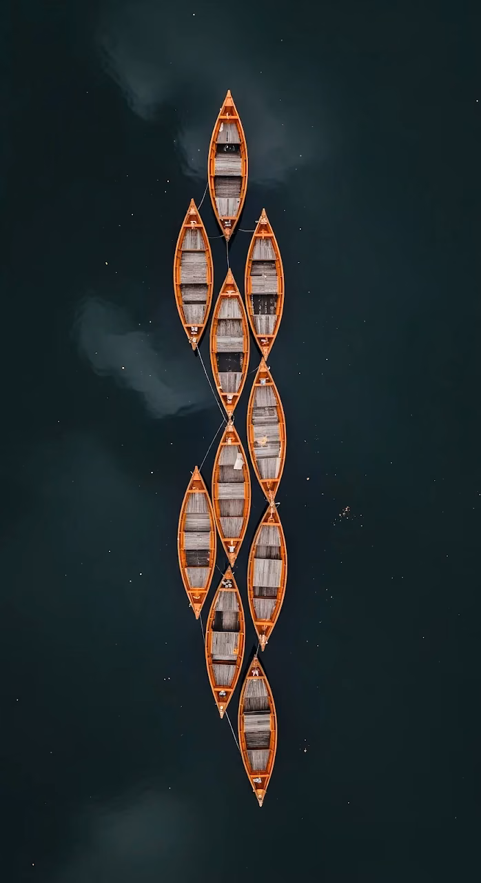 Overhead View of Nine Orange Wooden Rowboats on Dark Water - Free Mobile AMOLED Wallpaper Background