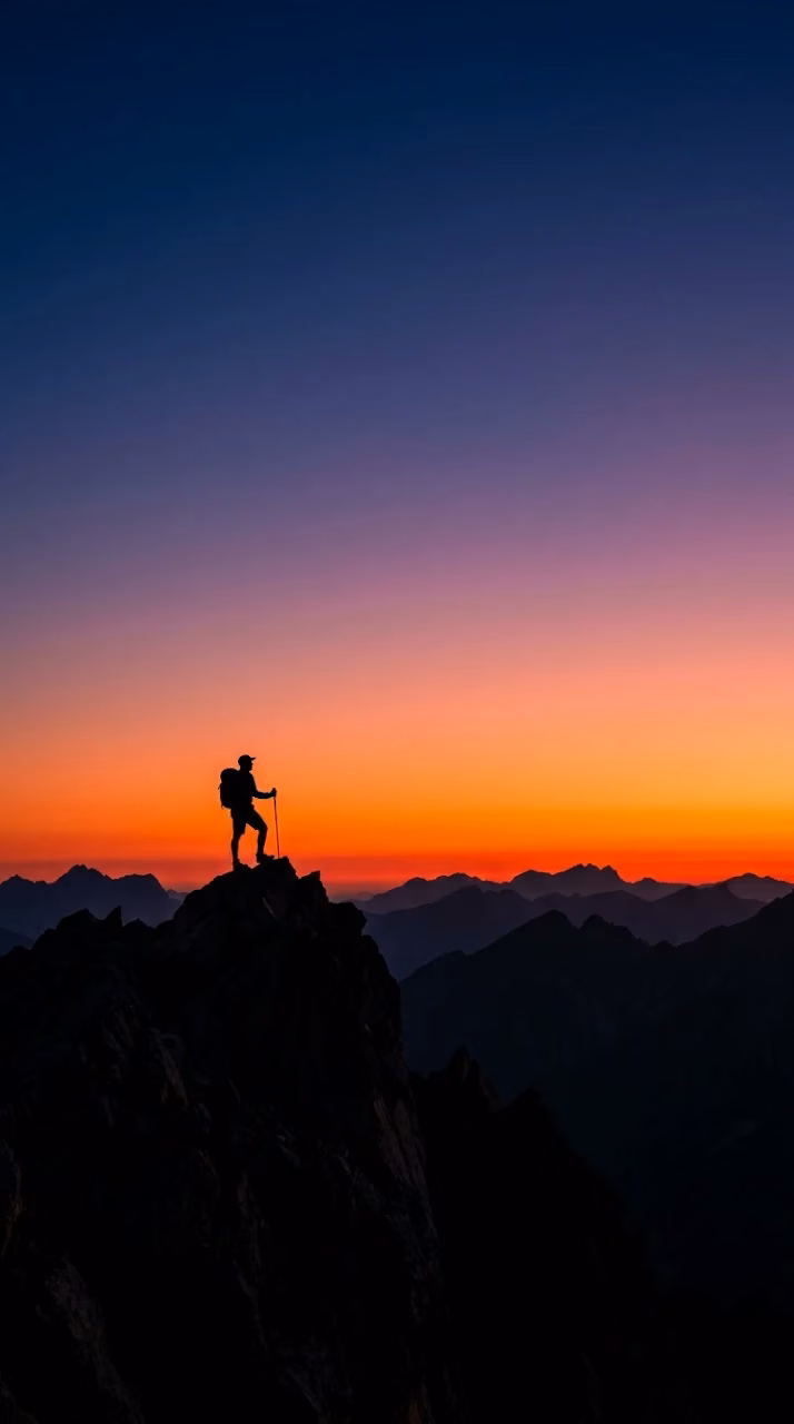 Silhouette of a Lone Hiker on a Peak Against Fiery Red Dawn Sky - Free Mobile AMOLED Wallpaper Background