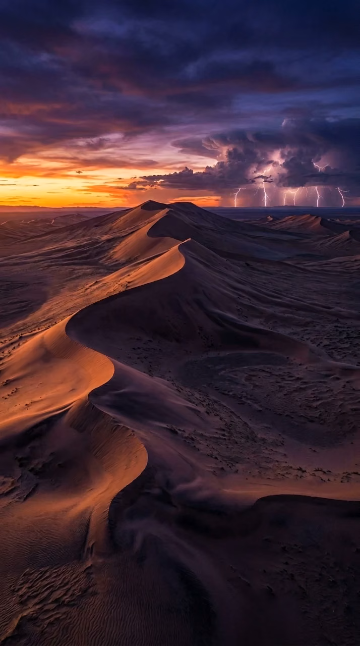 Surreal Desert Landscape at Twilight with Distant Lightning Storm - Free Mobile AMOLED Wallpaper Background