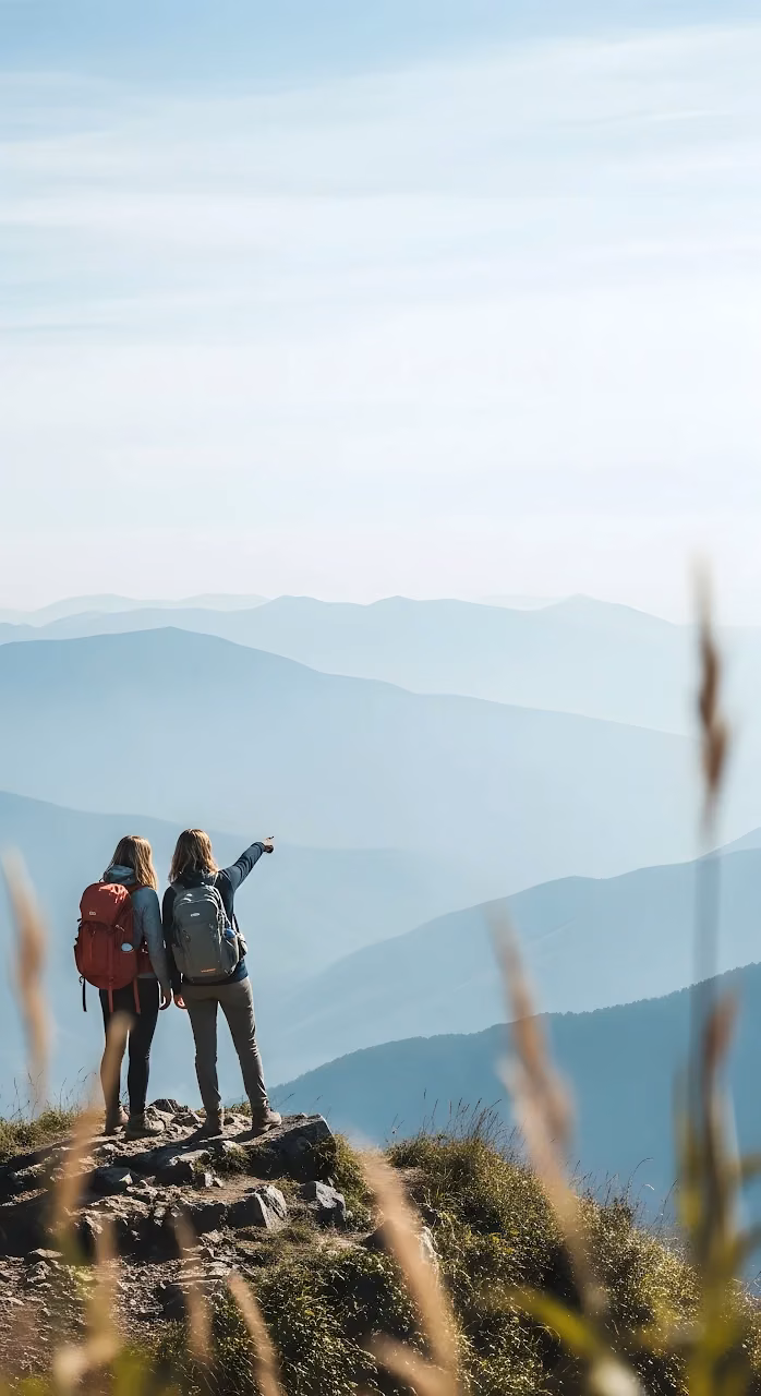 Two Hikers Viewing Layered Blue Mountain Vista - Free Mobile AMOLED Wallpaper Background