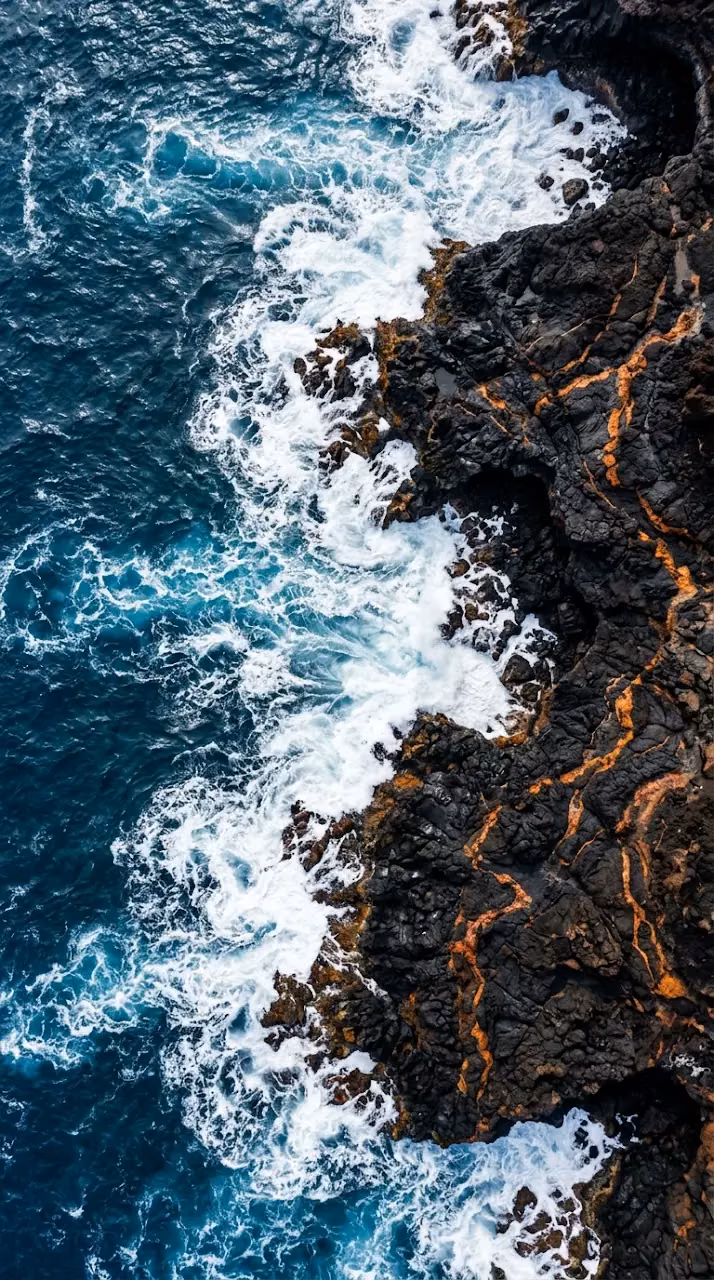 Download Vertical Aerial View of Black Volcanic Rock Meeting Deep Blue Ocean Wallpaper in Mobile HD Vertical Aerial View of Black Volcanic Rock Meeting Deep Blue Ocean - Free Mobile AMOLED Wallpaper Background