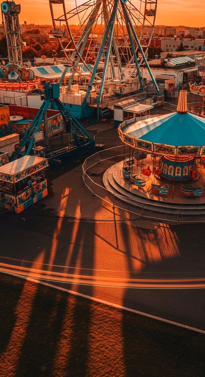 Vibrant Carnival Fairground with Ferris Wheel at Sunset - Free Mobile AMOLED Wallpaper Background