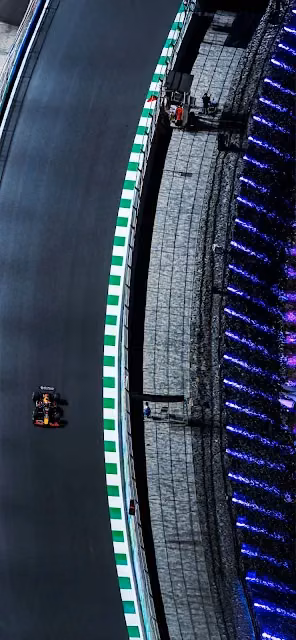 F1 Race Car Speeding on Track with Neon Lights at Night - Free 4K & 8K Mobile Wallpaper