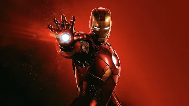 Iron Man aims an activated repulsor blast forward against a solid red studio background. Iron Man in red and gold armor with glowing eyes and chest reactor, aiming a white repulsor hand beam on a red background.