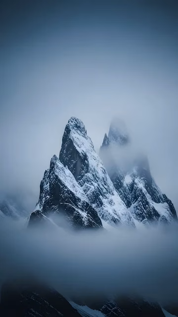 Jagged Snow-Covered Alpine Peaks in Dense Fog - Free 4K & 8K Mobile Wallpaper