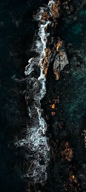 Moody Aerial View of Crashing Waves on Dark Volcanic Coastline - Free 4K & 8K Mobile Wallpaper