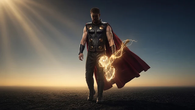 Thor walks forward holding a glowing hammer as sunlight breaks across a desolate horizon. Thor in armor and a red cape walking forward on a dark field while holding an electrified glowing hammer under sunlight.